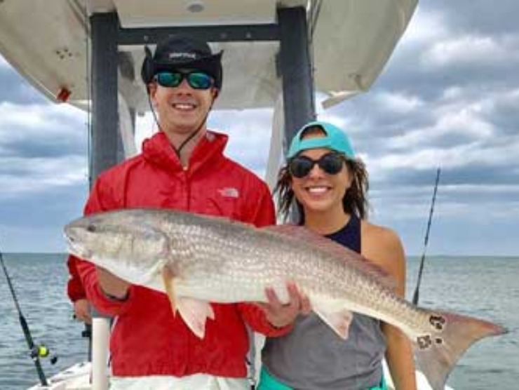 Man and Woman Holding a Long Fish | Fishing Charters in Jacksonville, FL - Fish Hunter Charters